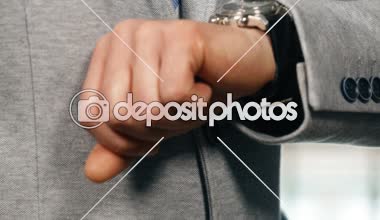 Onun saati kontrol işadamı kravat ve ceket, düzenleme yüze eğimli