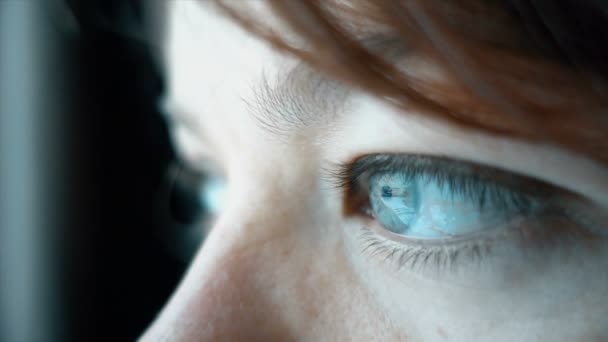 Gros plan de belle femme aux yeux bleus regardant par la fenêtre, au ralenti 