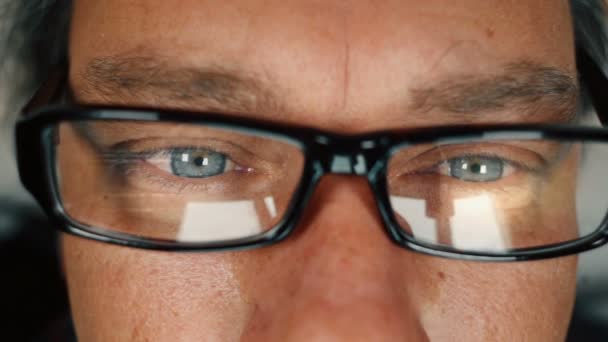 Close up of man with blue eyes working on computer and taking off eyeglasses to rub his eyes — Stock Video