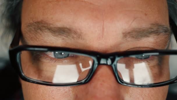 Close up of man with blue eyes reading and taking off eyeglasses to rub his eyes — Stock Video