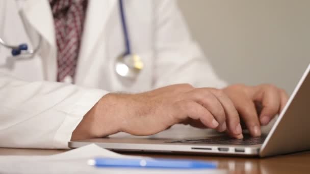 Lékař pacienta lékařské údaje o notebooku a mluví o mobilní telefon, zblízka — Stock video