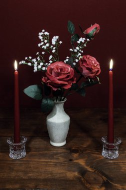 Bir vazo acsented karanfil çiçek, kristal tutucu iki kırmızı mumlar ile güzel pembe güller. 