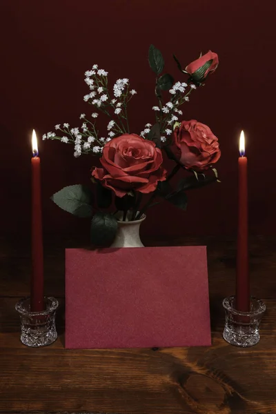 赤ちゃんの呼吸の花でアクセントをつけた花瓶の美しいピンクのバラ つ蝋燭 結晶ホルダーとカードで ストック画像