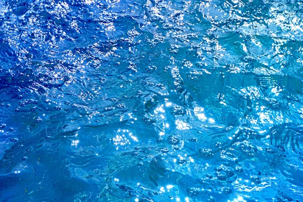 Pęcherzyki powietrza na gładkiej powierzchni niebieskiej wody — Zdjęcie stockowe