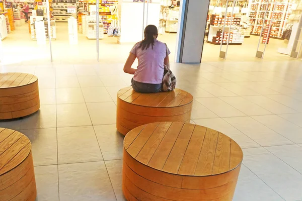 Meisje zittend voor een winkel — Stockfoto