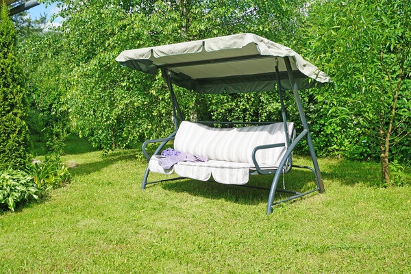 Garden swing sofa in the summer outdoors                               
