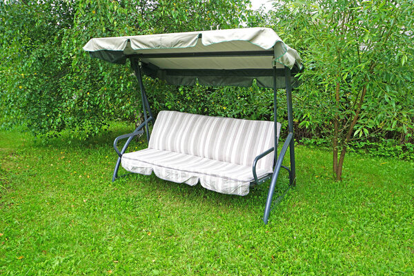 Garden swing sofa in the summer outdoors                               