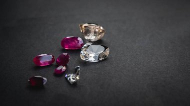Kırmızı yakut ve topaz koleksiyonu, siyah kağıt üzerindeki mücevherler için değerli taşlar.