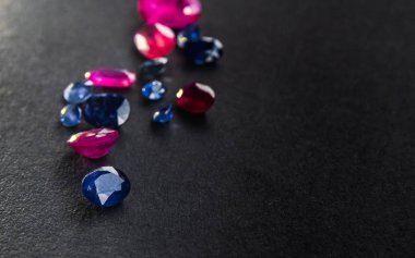 Kırmızı yakut ve mavi safir koleksiyonu siyah arkaplandaki mücevherler için değerli taşlar.