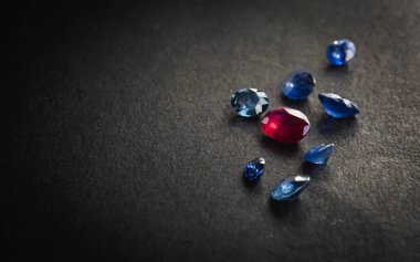 Kırmızı yakut ve mavi safir koleksiyonu siyah arkaplandaki mücevherler için değerli taşlar.