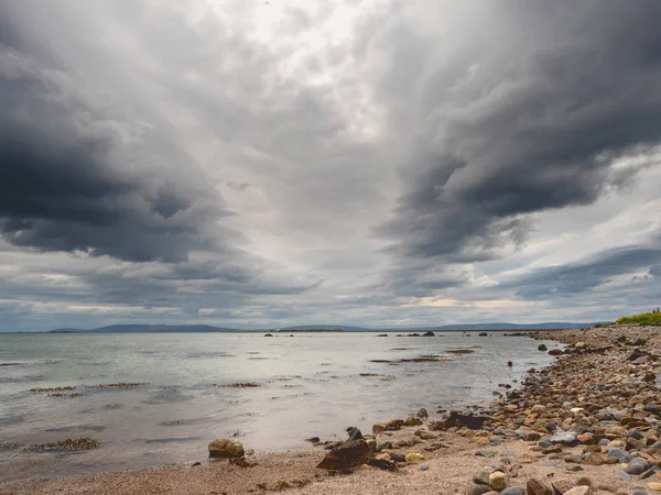 Dramatische hemel boven Galway Bay, Atlantische Oceaan, Burren op de achtergrond. Kalm water. — Stockfoto