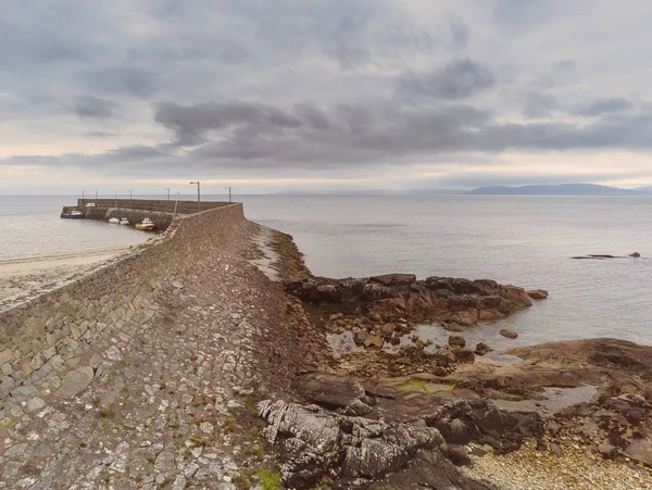 Wave Breaker en Pier, Spiddal, County Galway, Ierland, Burren op de achtergrond. Bewolkte hemel, Atlantische Oceaan. — Stockfoto
