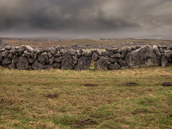 Traditionella torra sten staket i ett fält, dramatiska moln i himlen. — Stockfoto