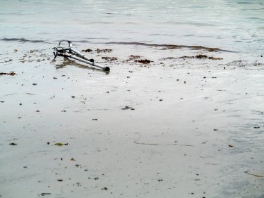 Su kenarındaki kumda eski kullanılmış koltuk değnekleri. Konsept sağlık, Su kurtarma prosedürü. Kopya alanı. Kimse.
