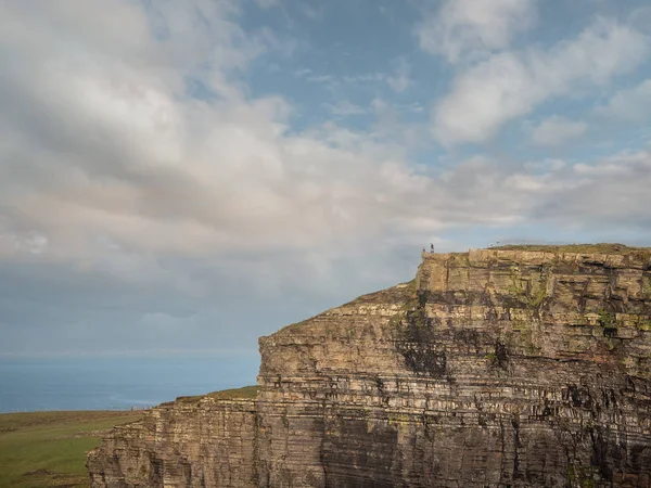 Cliff of Moher structuur, en toeristen staan op de rand. Concept veiligheid, toerisme, oriëntatiepunt. — Stockfoto