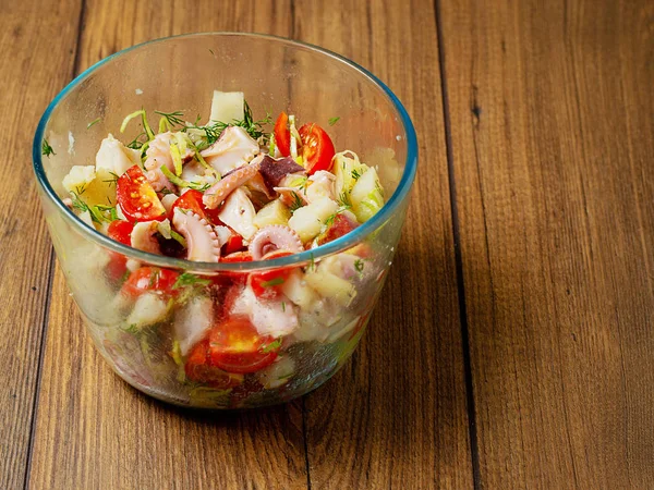 Taze domates, pırasa, dereotu, otlar ve zeytinyağı ile taze ahtapot salatası ahşap bir yüzey, Kopya alanı.