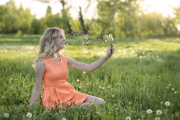 Güzellik sarışın model kız ve kokulu karahindiba çiçekler. Anti ücretsiz. Sağlıklı gülümseyen kız portre