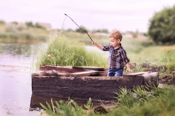 Ragazzino pesca al tramonto sul fiume — Foto Stock