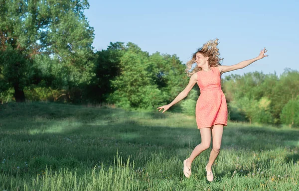 genç ve güzel kadın yeşil çimenlerin üzerinde atlama
