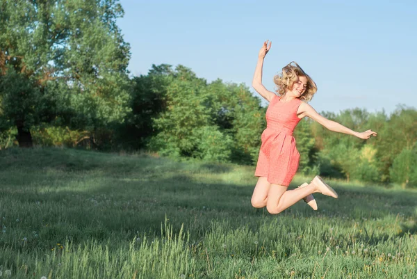 genç ve güzel kadın yeşil çimenlerin üzerinde atlama