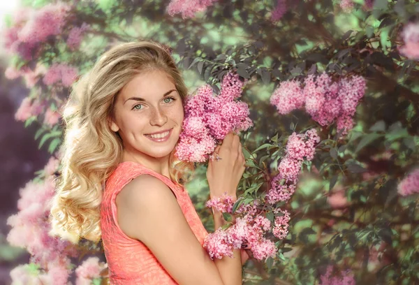 Giovane bella donna vicino all'arbusto fiorito — Foto Stock