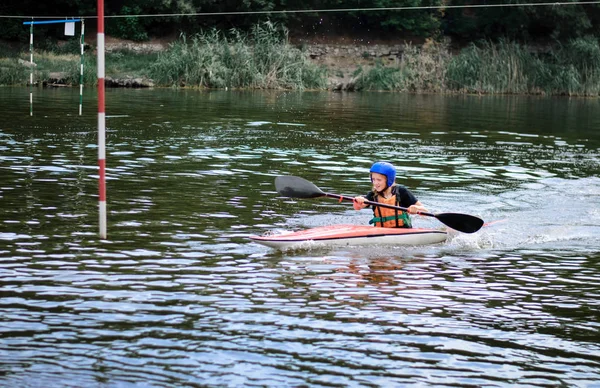 Joven adolescente chica activamente maneja un barco de kayak deportivo en un hermoso río —  Fotos de Stock