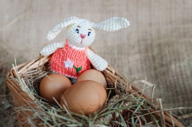 Paskalya dekor yumurta, gri arka planda örme tavşan. El yapımı