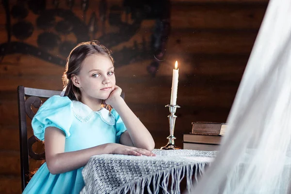 Güzel küçük kız mum ışığına karanlık arka plan, din ve folklor konsepti, yakın plan portre üzerinden bakıyor.