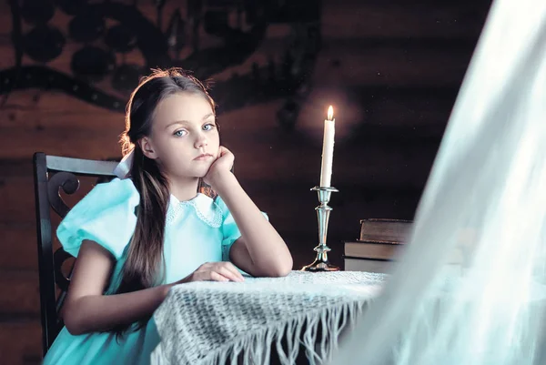 Güzel küçük kız mum ışığına karanlık arka plan, din ve folklor konsepti, yakın plan portre üzerinden bakıyor.