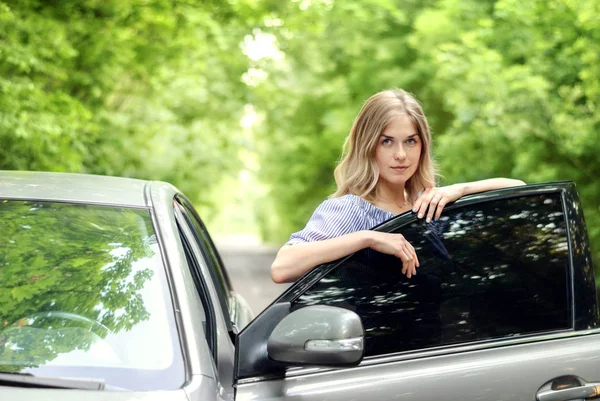 Женщина, стоящая возле машины — стоковое фото