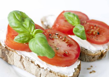 Beyaz arka planda domatesli ev yapımı sandviçler.