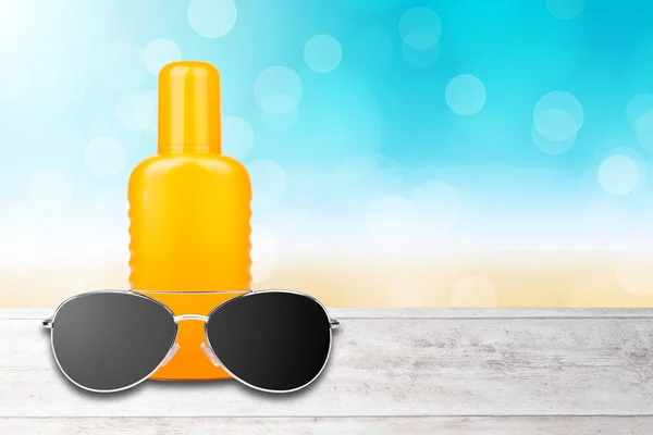 Oranje Fles Zonnebrandcrème Zonnebril Een Onscherpe Lucht Achtergrond — Stockfoto