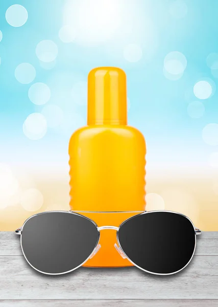 Oranje Fles Zonnebrandcrème Zonnebril Een Onscherpe Lucht Achtergrond — Stockfoto