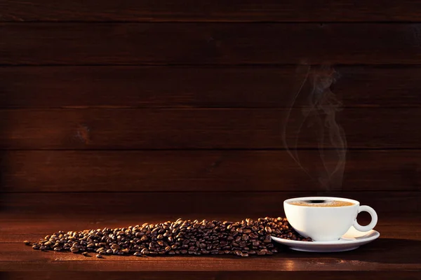 茶色の木の背景に散在するカップ プレート コーヒー豆とまだ生活 ロイヤリティフリーのストック画像