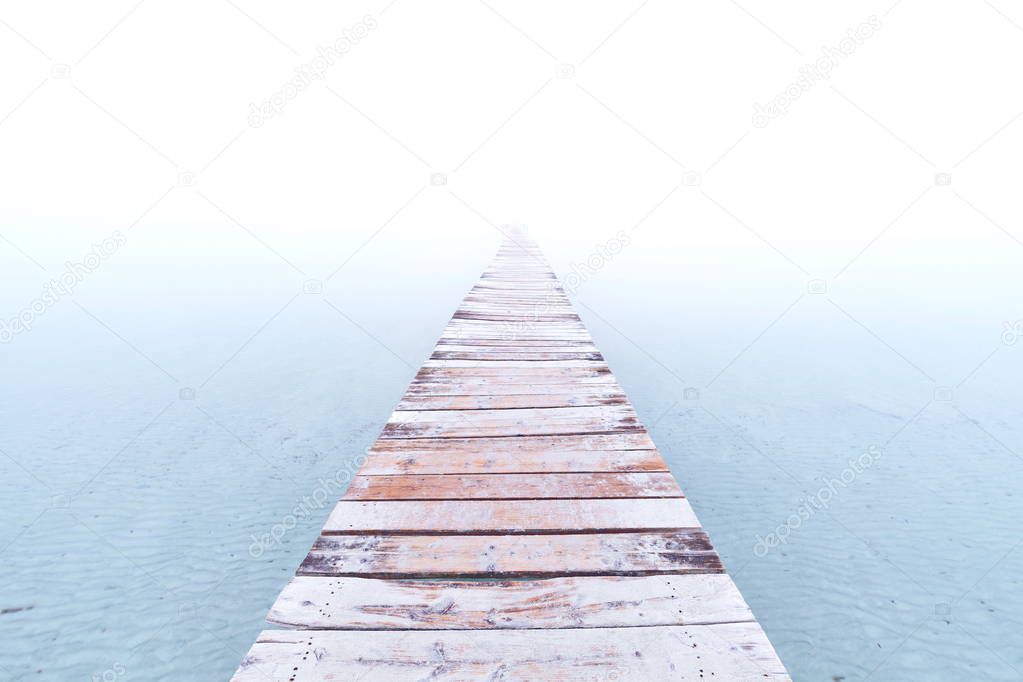 Foggy river with shabby wooden pier