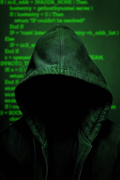 Silhouette of hacker in hoodie on technology code background