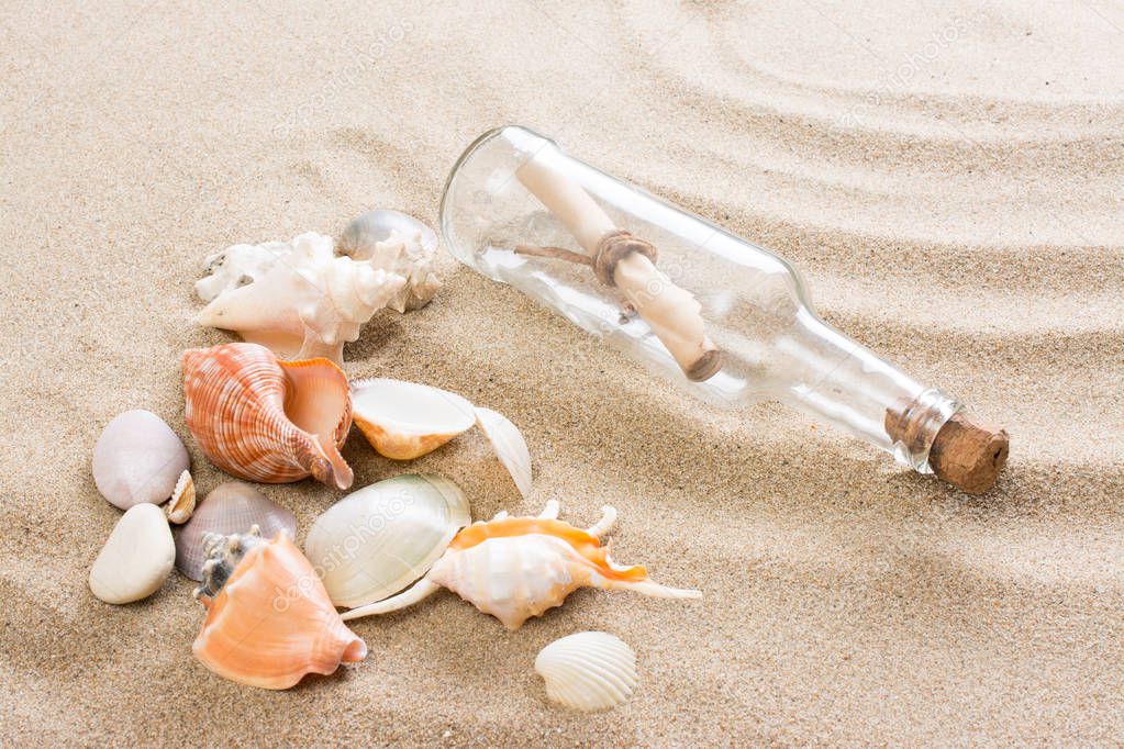 Message in bottle on the beach. Summer background with hot sand