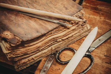 Restorasyon laboratuvar. Eski kitaplar araçları ve ekipmanları ile çevrili.