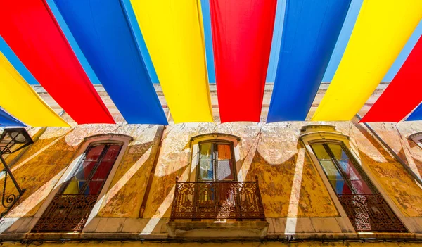 Colorful awning on the street in summer. Outdoor view of the typical architecture of the city of Loule, Portugal.