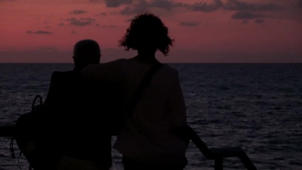 一对成熟的夫妇在意大利塞法尔市的海面上观看日落 天空多云的太阳 — 图库视频影像