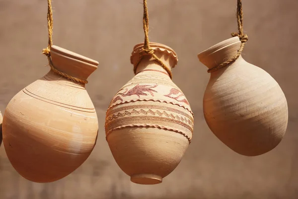 Ceramic jars hanging on ropes on sale in Nizwa market,Oman