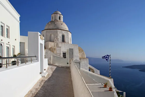 Small orthodox church with Greek flag in Fira,Santorini island,Greece