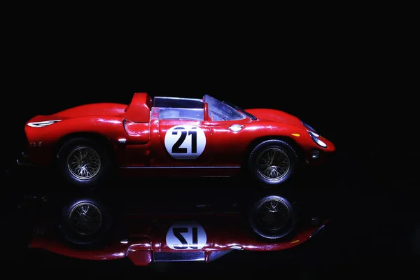 Classic red sport car model scale on black background