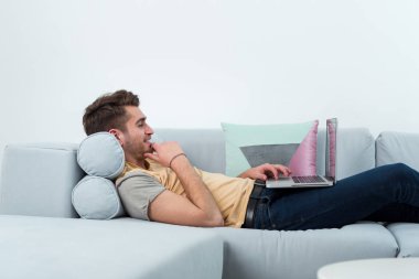teknoloji, ev ve yaşam kavramı - laptop ile evde çalışan adam gülümsüyor