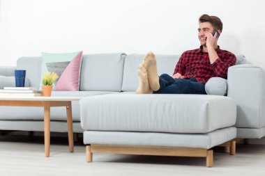 mobil telefonda konuşurken ve koltukta yalan gülümseyen adam