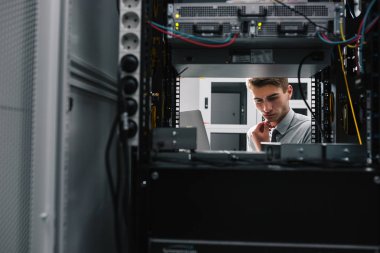 Genç yakışıklı iş adamı veritabanı sunucu odasında.