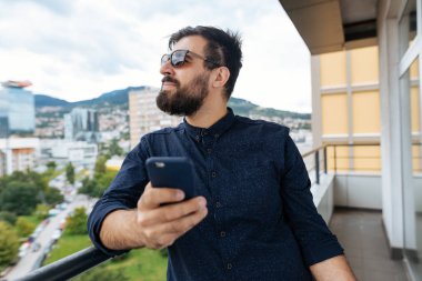 Çatı cep telefonu kullanan genç yakışıklı adam