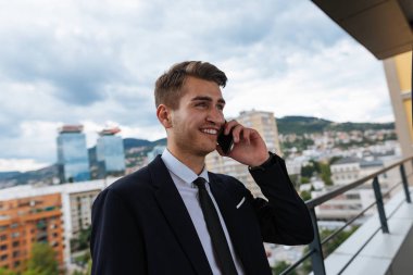 Çatı cep telefonu kullanan genç yakışıklı adam