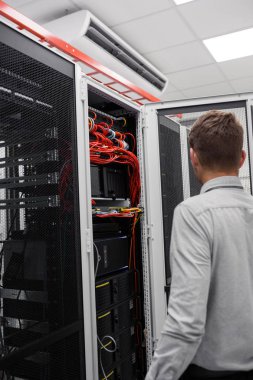  Genç adam Server supercomputer içinde veri merkezi ile çalışırken kabine telleri bağlarken