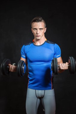 Genç erkek fitness modeli halter tutar